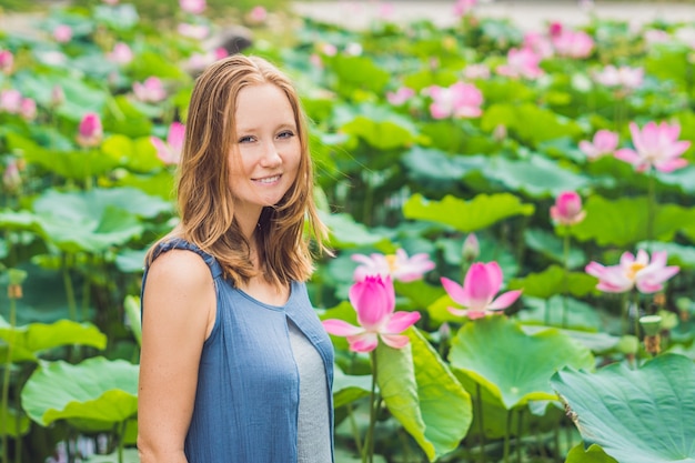 蓮の花を手に赤毛の美女の写真。