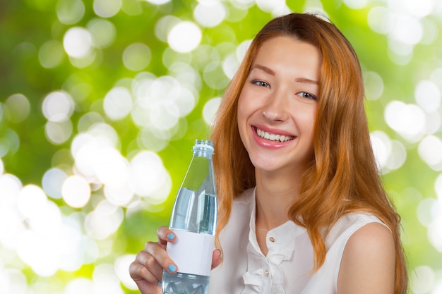 水のボトルを持つ美しい女性の写真