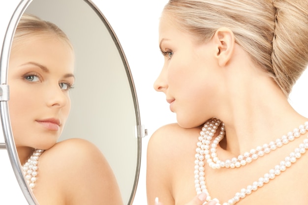 picture of beautiful woman with pearl beads and mirror.