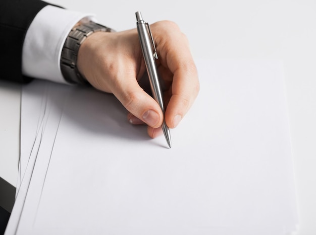 Photo picture of businessman writing something on the paper