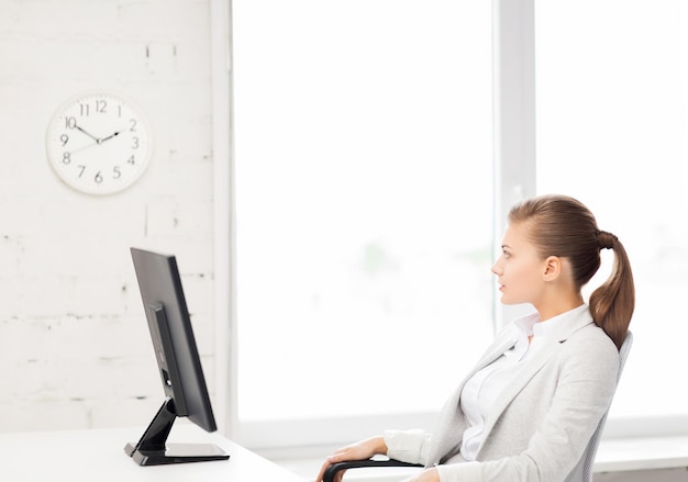 Foto di una donna d'affari che guarda l'orologio da parete in ufficio