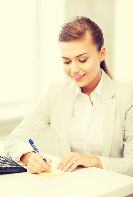 picture of businesswoman writing on sticky note