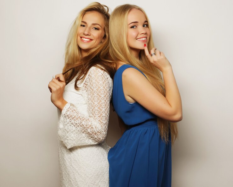 Photo picture of a charming young girls friends in dress on white background