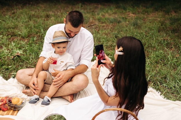 Foto di allegra mamma caucasica, papà e il loro bambino si divertono insieme e sorridono in giardino