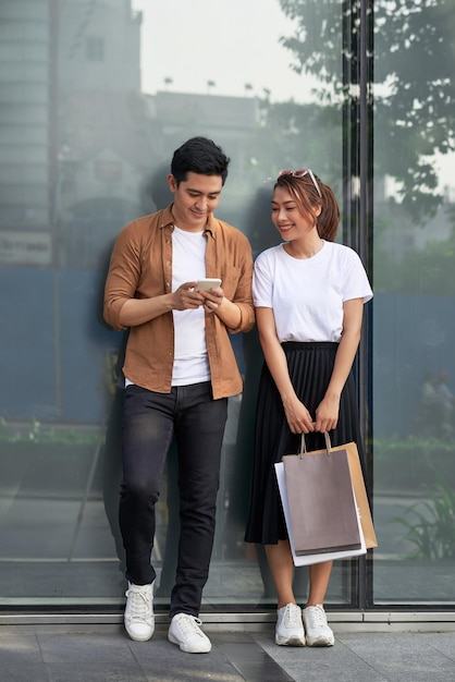 A picture of a couple shopping with smartphone in the city