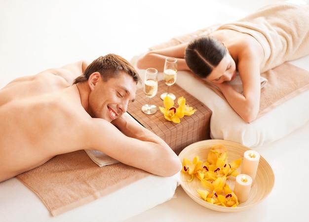 Foto di una coppia nel salone della spa sdraiata sui lettini per massaggi