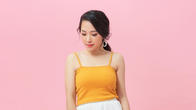 Picture of cute young smiling lady standing isolated over pink background