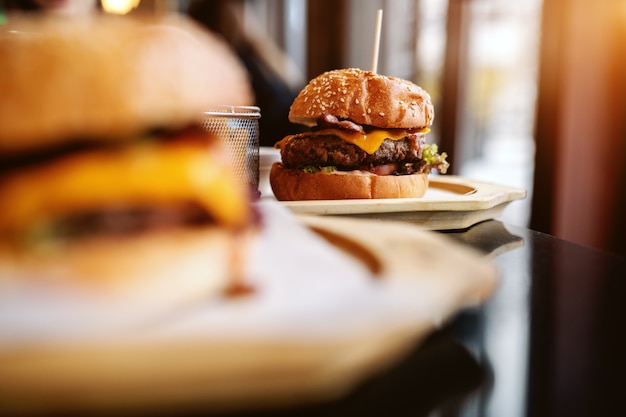 Картина вкусных гамбургеров на столе. Селективный акцент на гамбургере в фоновом режиме.