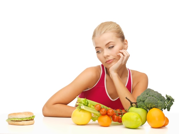 picture of doubting woman with fruits and hamburger