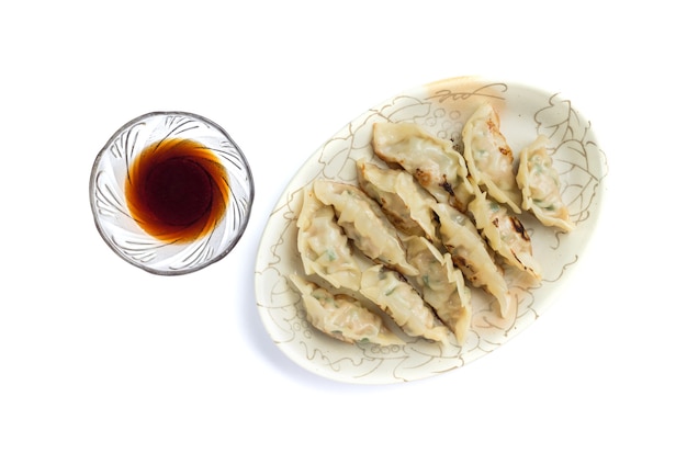 Foto di gnocchi o gyoza con salsa di soia isolati su sfondo bianco