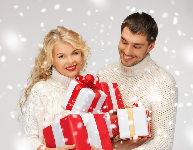 картина семейной пары в свитере с подарочными коробками