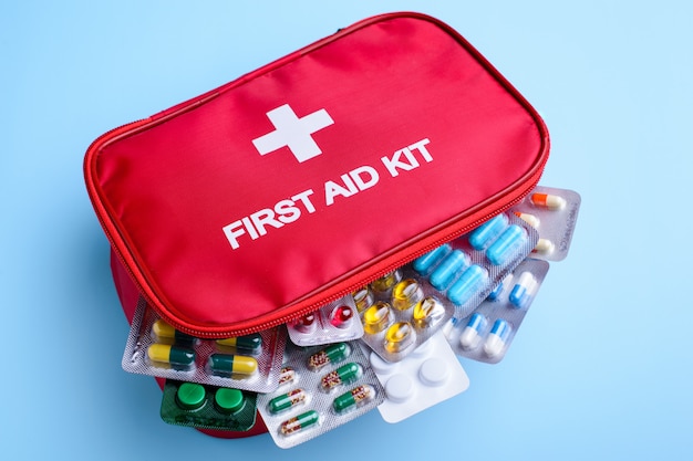 Photo picture of first aid kid full of different pils for any occasian on light blue background