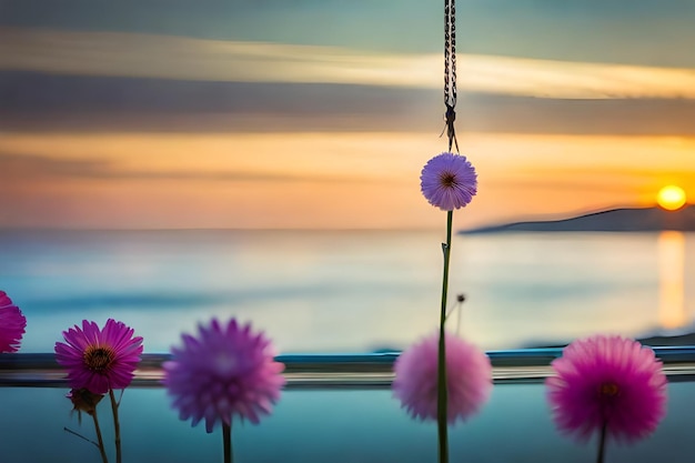 Photo a picture of flowers hanging from a rope with the ocean in the background