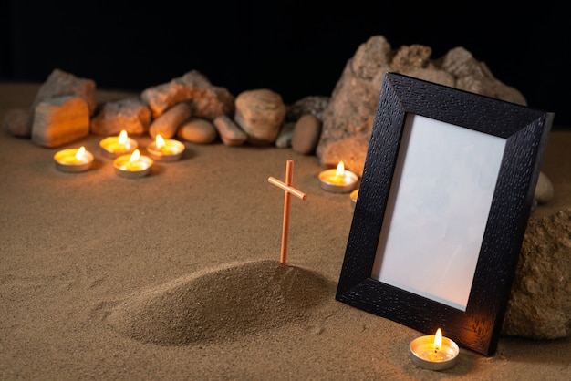 Picture frame with stones candles and little grave dark surface