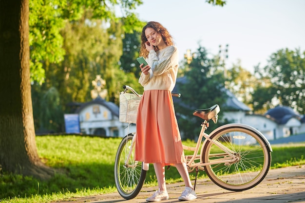 公園で自転車を持っている女の子の写真