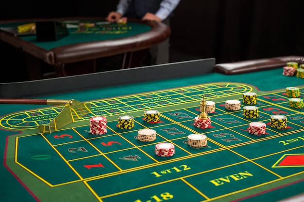 Photo picture of a green table and betting with chips. close up