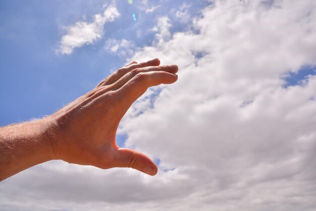 Picture of an Hand over a Cloudy Sky