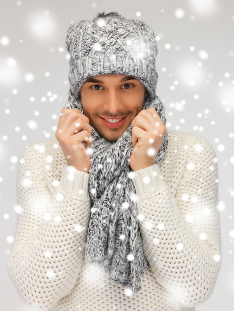 따뜻한 스웨터, 모자와 스카프에 잘생긴 남자의 그림.