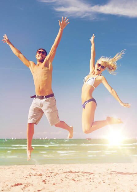 picture of happy couple jumping on the beach