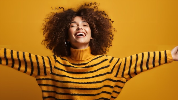 노란색 배경에서 팔을 들고 흔들고 있는 줄무 ⁇  스웨터를 입은 행복한 이색적인 소녀의 사진