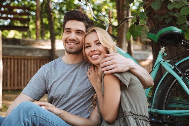 Photo picture of happy lovely young couple having rest together and looking at the camera outdoors