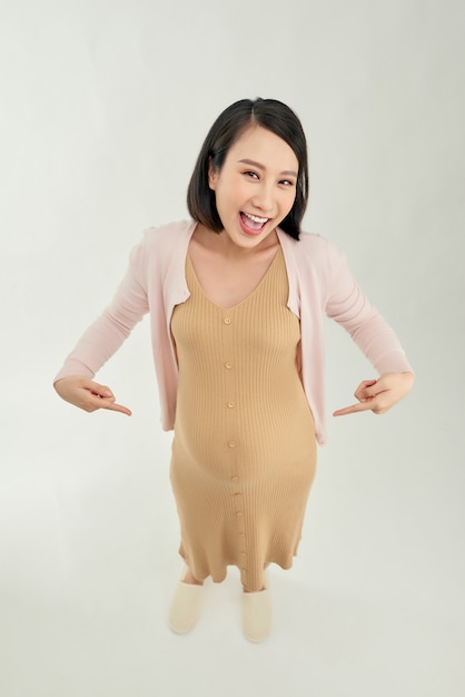 Picture of happy pregnant woman posing isolated over white wall