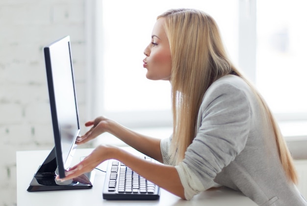 picture of happy woman kissing computer monitor