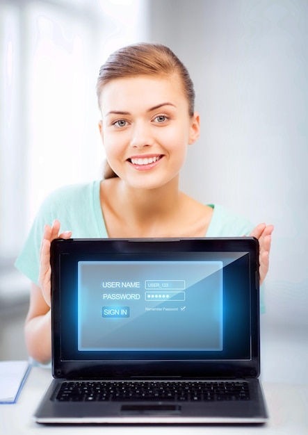 ラップトップコンピューターと仮想画面を持つ幸せな女性の写真