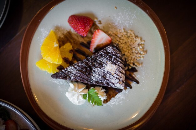 Immagine dei brownies al cioccolato fondente fatti in casa e fragola e arancia fresca