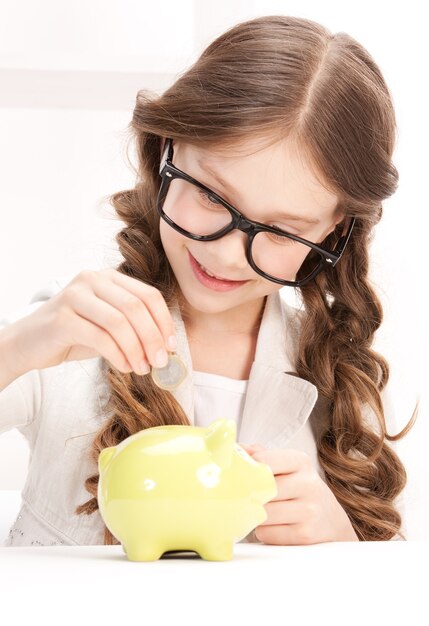 picture of little girl with piggy bank and coin