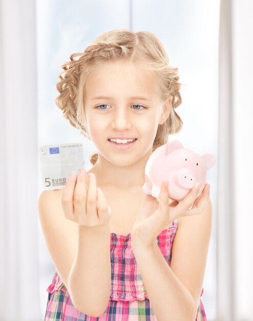 Photo picture of little girl with piggy bank and money