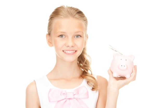 돼지 저금통과 돈을 가진 사랑스러운 십대 소녀의 사진