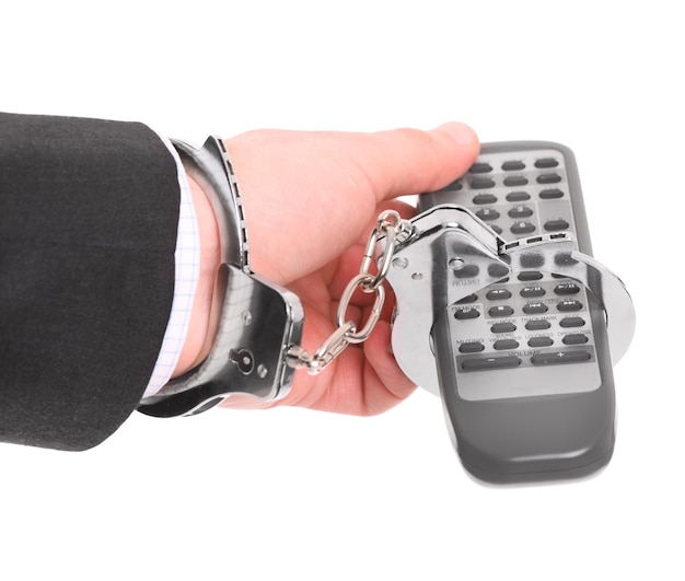 Photo a picture of a male hand chained to remote control over white background