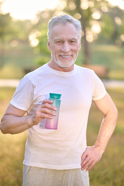 Photo a picture of a man with a bottle of water in hands