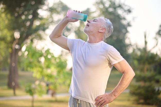 A picture of a man with a bottle of water in hands