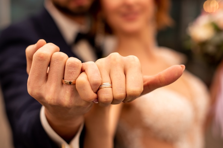 Photo picture of man and woman with wedding ring holding fingers