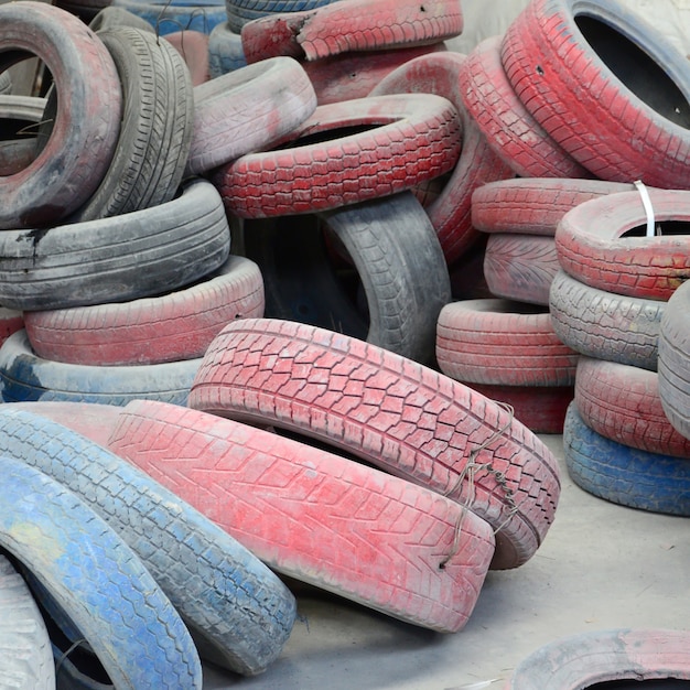 Un'immagine di molti vecchi pneumatici usati lasciati su una discarica