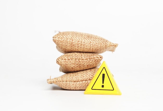 A picture of miniature grain bags with warning sign Caution of shortage food supply concept