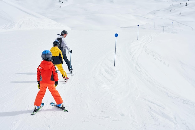 Photo picture of mother teach skiing her kids in madonna di campiglio