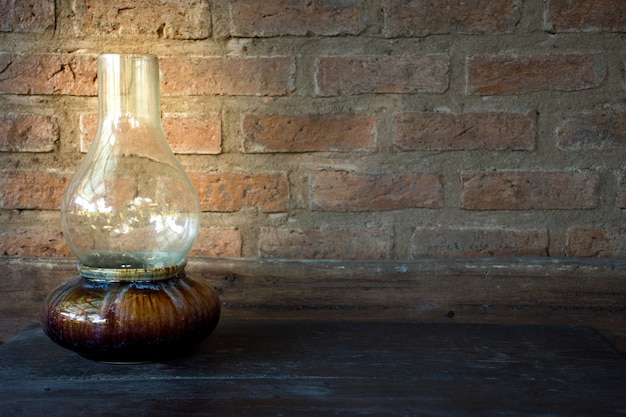 Picture of Oil Lamp at night on a wooden table with old brick wall background