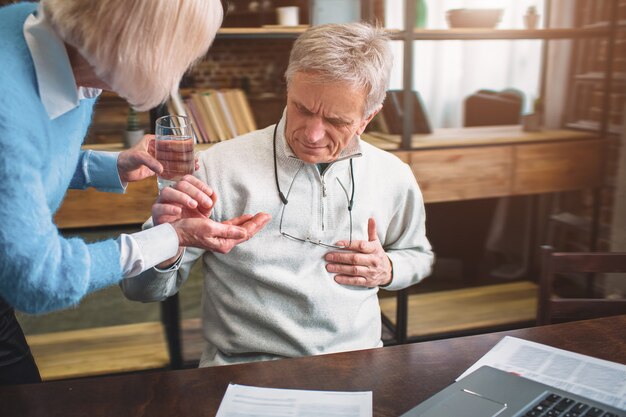 A picture of old man keeping his hand on the chest