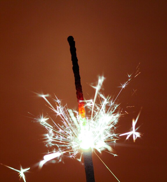 Foto immagine di uno sparkler di partito su sfondo marrone scuro