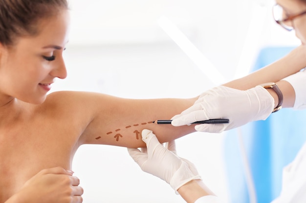 Picture of plastic plastic surgeon making marks on patient body