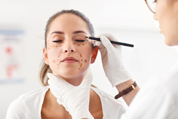 Picture of plastic plastic surgeon making marks on patient body