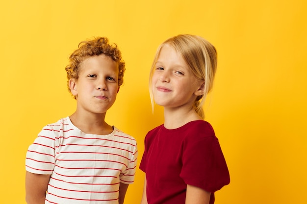 Изображение позитивного мальчика и девочки в повседневной одежде, веселых игр вместе на изолированном фоне