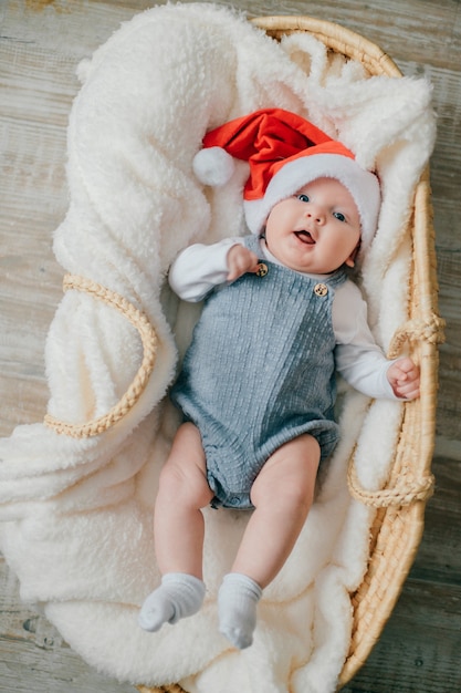 Picture of pretty newborn baby in Santa's Christmas cap and smiles