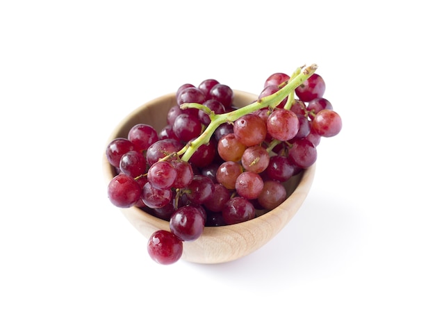 Picture of red grapes in a wooden bowl isolated on the white background