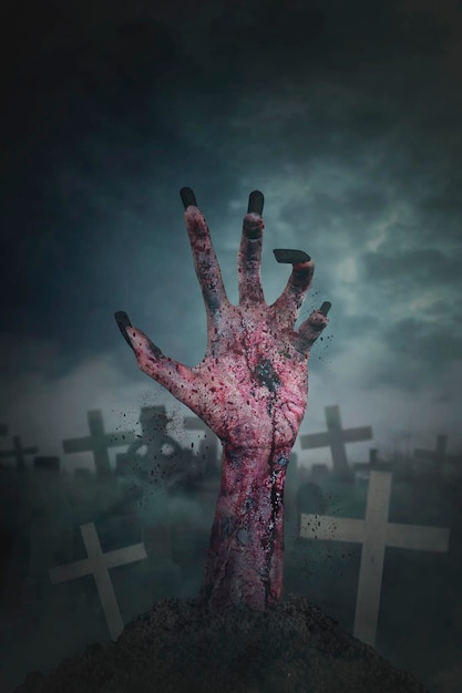 Picture of scary zombie hand coming out from graveyard at dark night