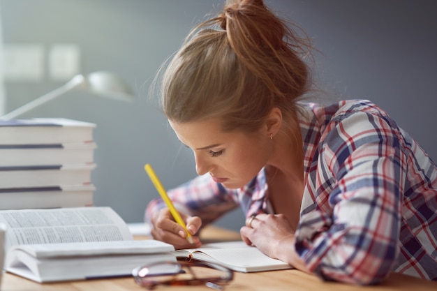 Foto immagine che mostra una studentessa che impara a casa