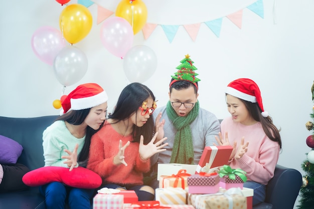 自宅でクリスマスを祝う友人のグループを示す画像。オフィスで幸せな驚いた友人